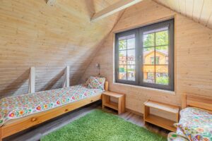 dwa lóżka pojedyncze przy oknie